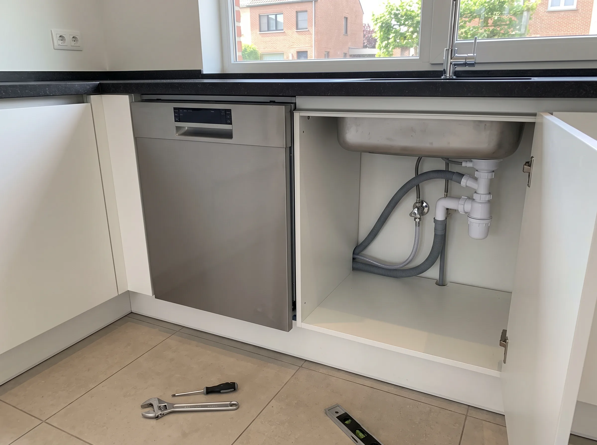 Installatie van vaatwasser met afvoerleidingen in keuken