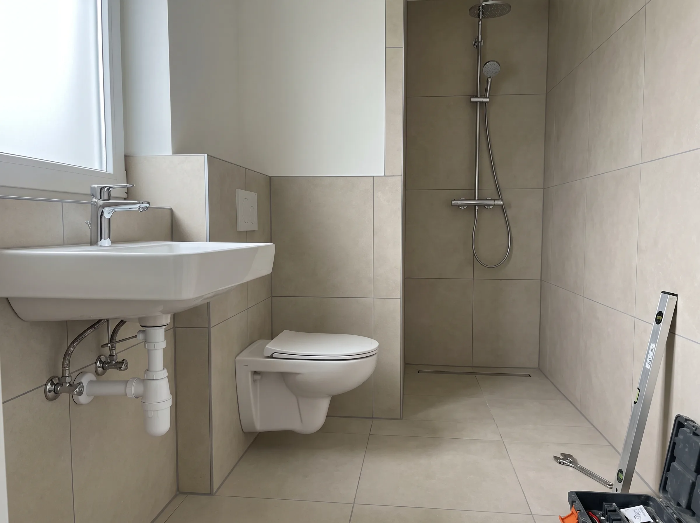 Modernisatie van sanitaire installatie in badkamer met wastafel en inloopdouche