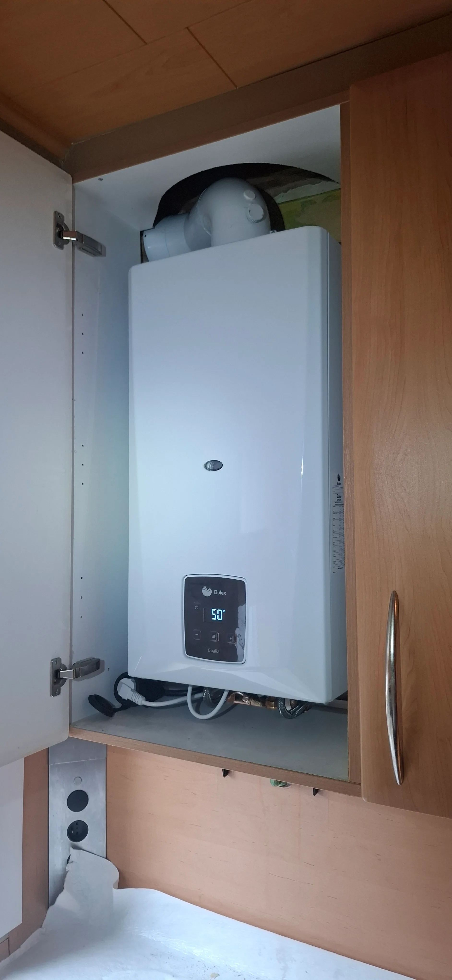 Een moderne warmwaterboiler geplaatst in een keukenkast