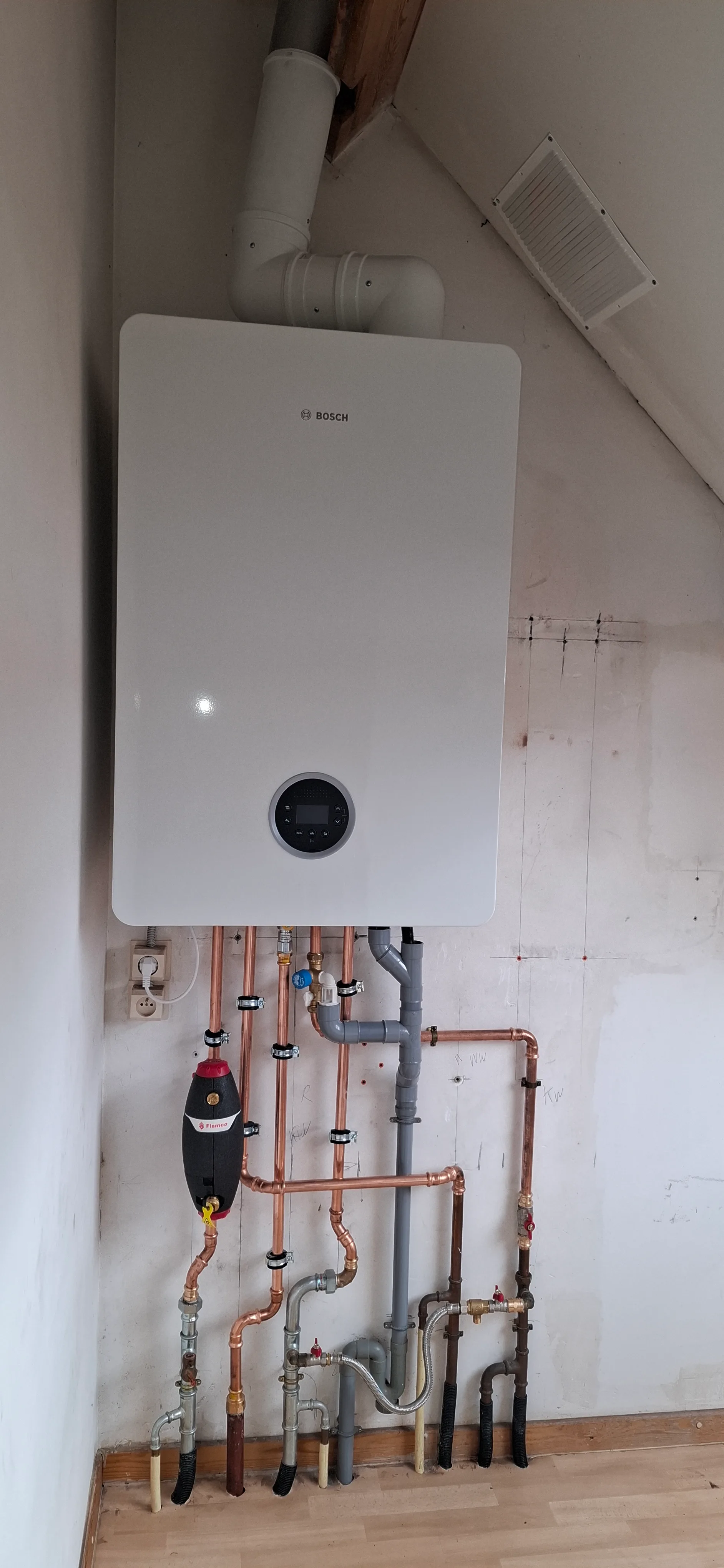 Een moderne gasketel met aanliggende leidingen in een technische ruimte