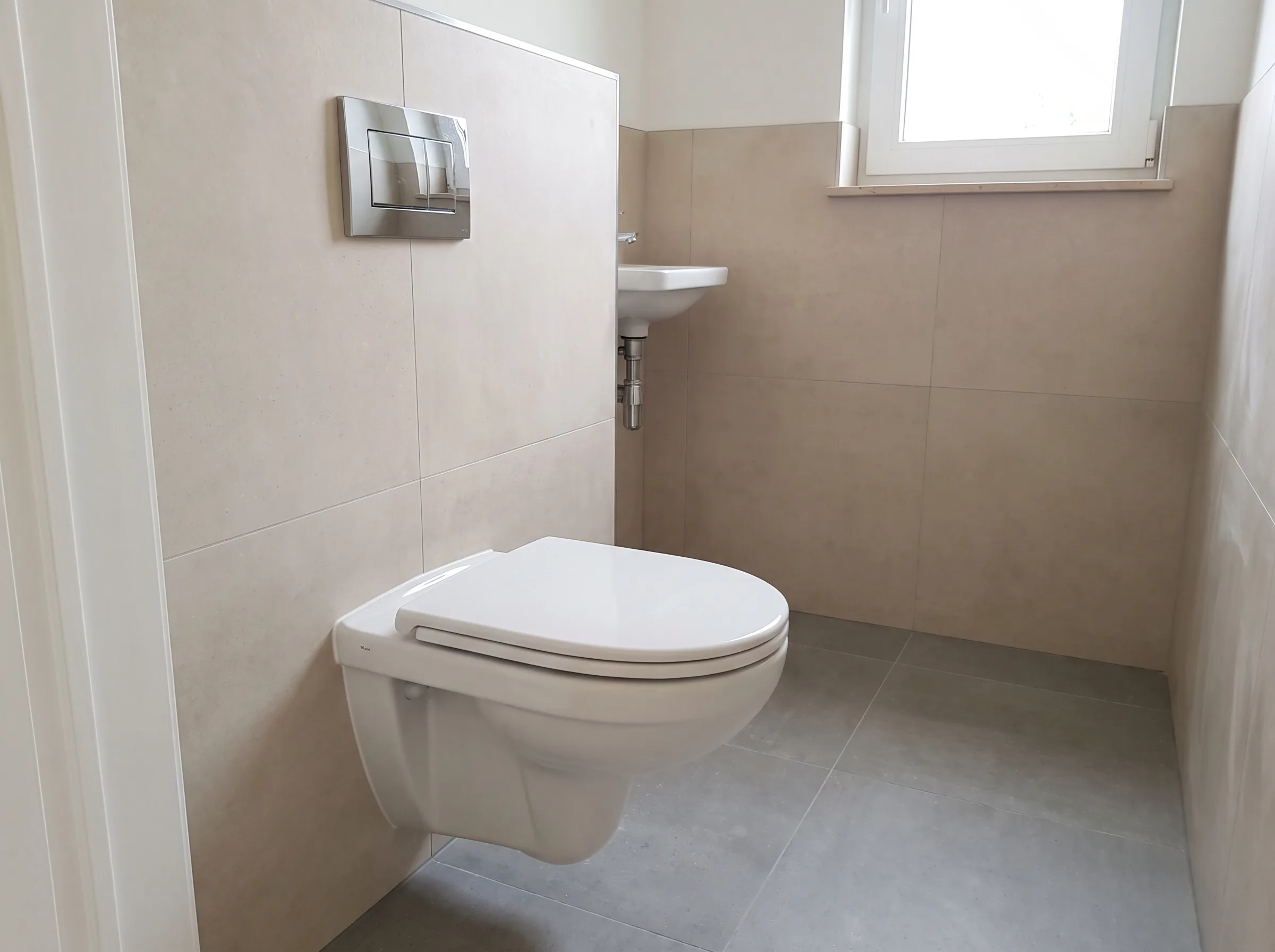 Modern toilet met wandcloset en wastafel in een lichte badkamer