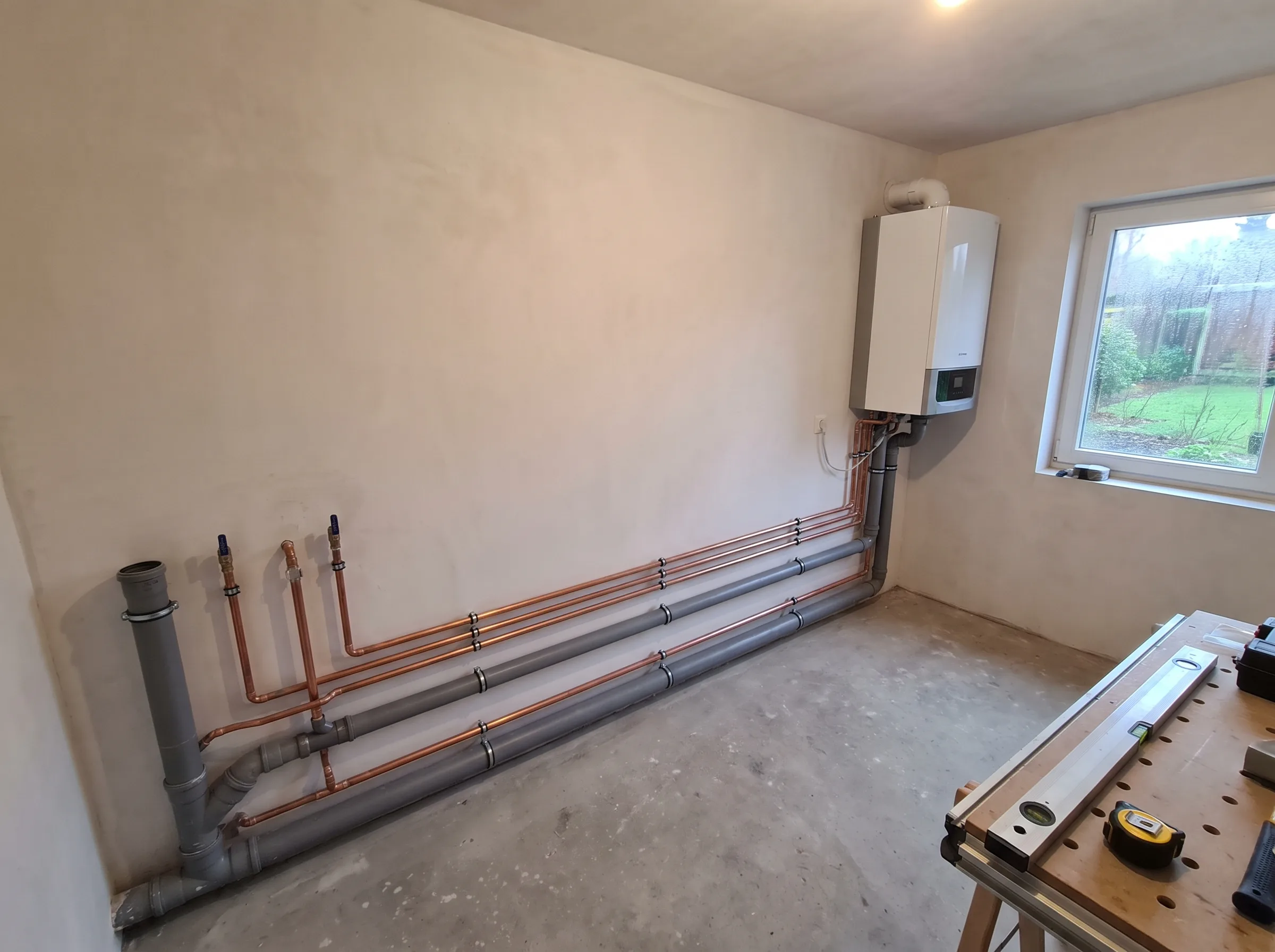 Nieuwe verwarmingsinstallatie met leidingen en boiler in technische ruimte