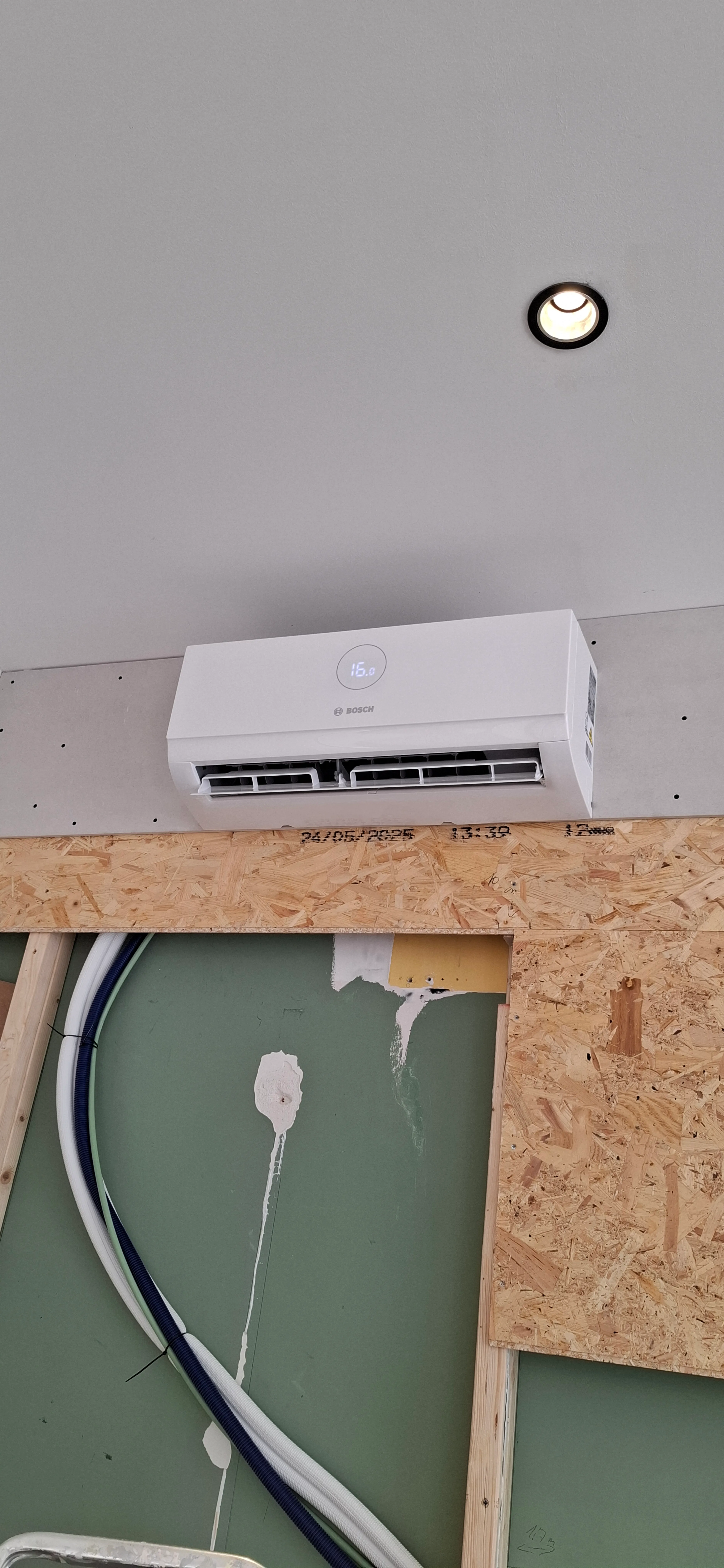 Installatie van een airco met zichtbare leidingen op de muur