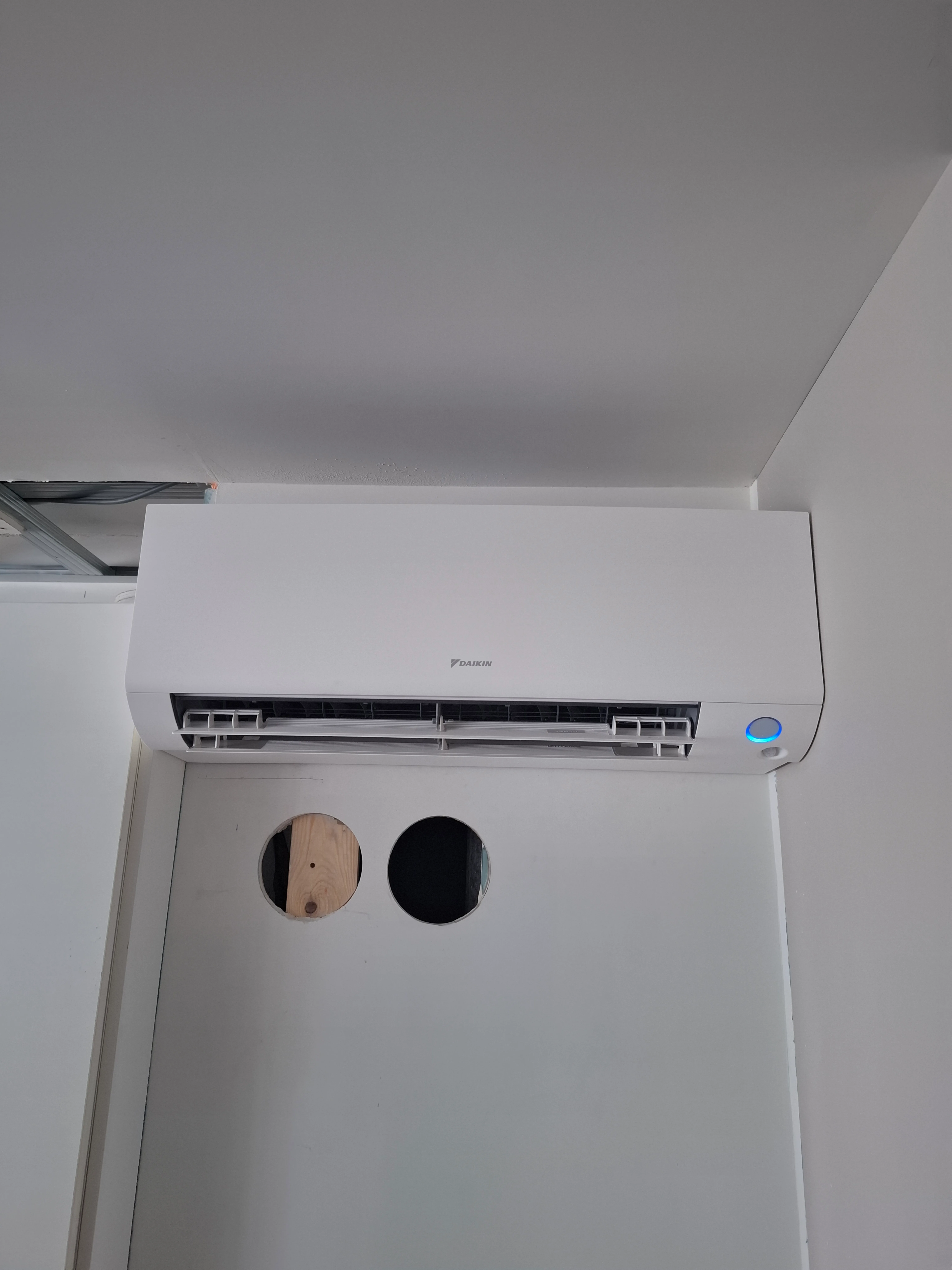 Installatie van een airco unit aan de muur met leidingen