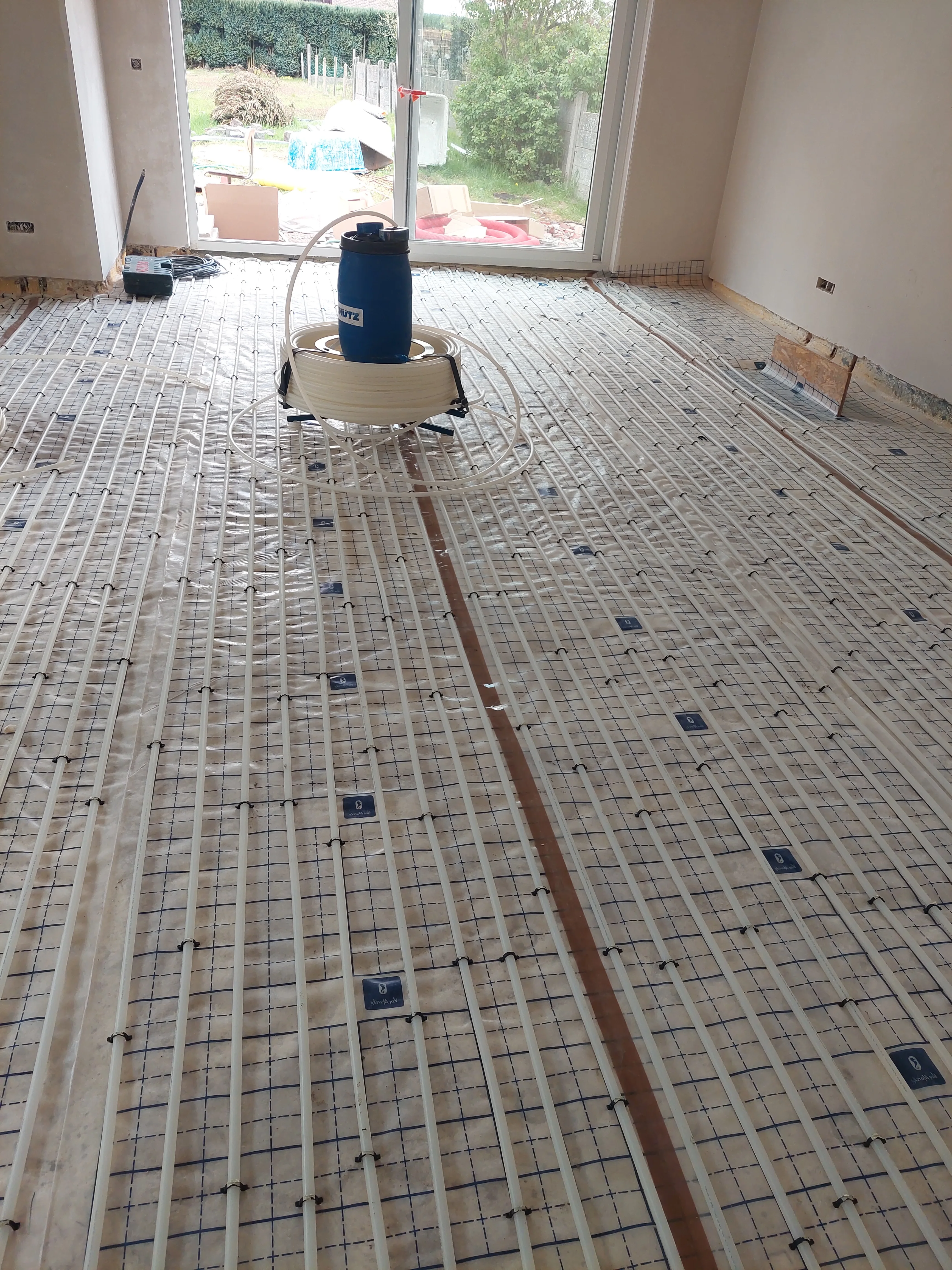 Vloerverwarming installatie in een renovatieruimte met leidingen op de vloer