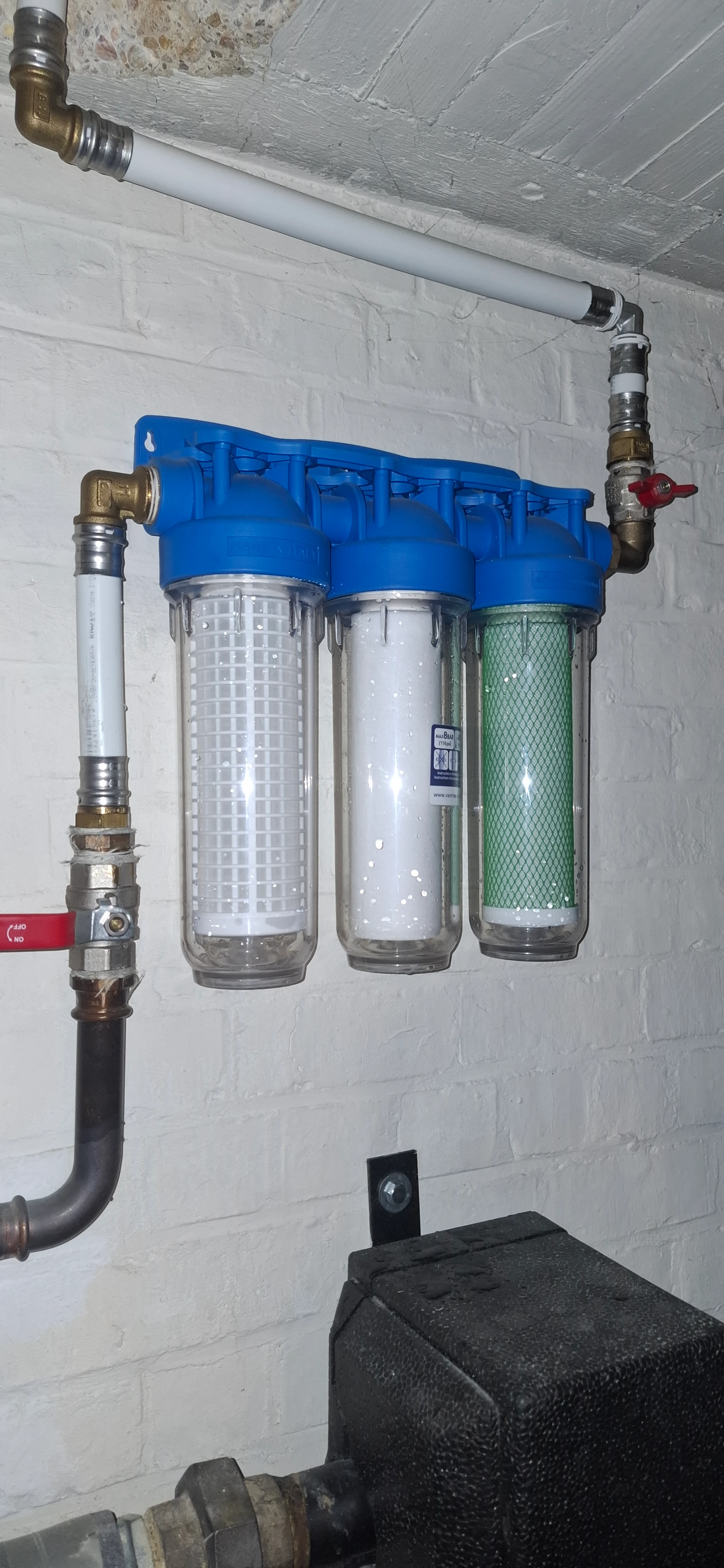 Waterfilter installatie met drie filters aan de muur gemonteerd